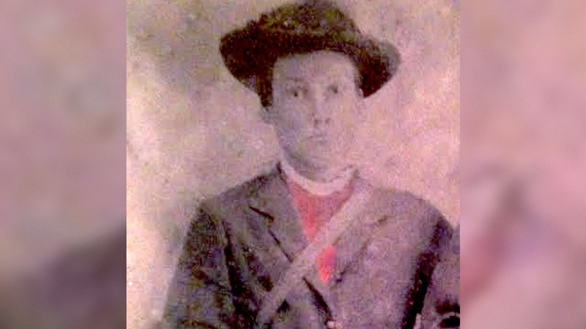 Historical portrait of a man in a hat and formal attire, showcasing early photography techniques and vintage clothing styles.