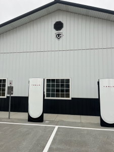 Tesla supercharging station in front of white building