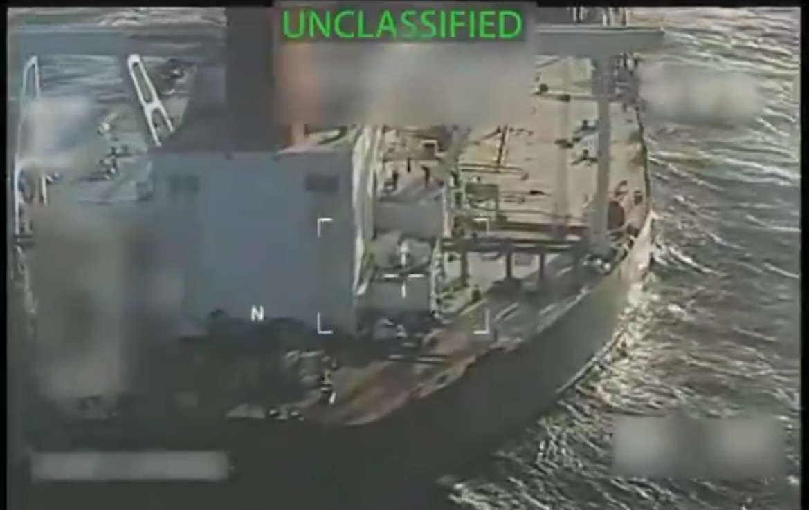 Aerial view of a cargo ship at sea, marked as unclassified, showcasing maritime operations and surveillance technology.