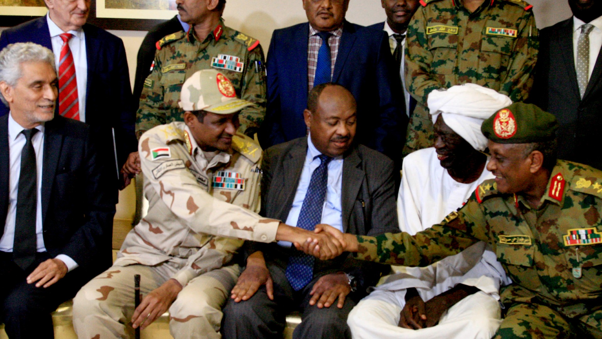 RSF leader Mohammed Hamdan Daglo, aka Hemedti, second left, shakes hands with Yasser al-Atta, right, at a news conference in Khartoum on 5 July 2019 (Ebrahim Hamid/AFP) RSF leader Mohammed Hamdan Daglo, aka Hemedti, second left, shakes hands with Yasser al-Atta, right, at a news conference in Khartoum on 5 July 2019 (Ebrahim Hamid/AFP)