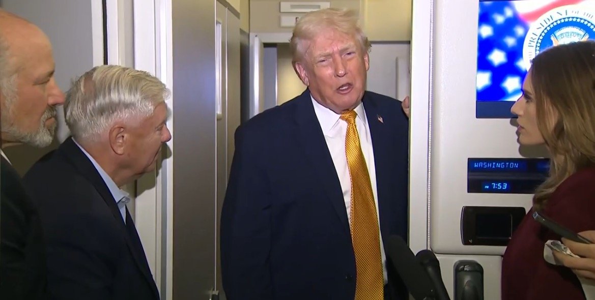 Donald Trump speaks with advisors and a journalist inside Air Force One, showcasing a moment of political discussion during a flight.