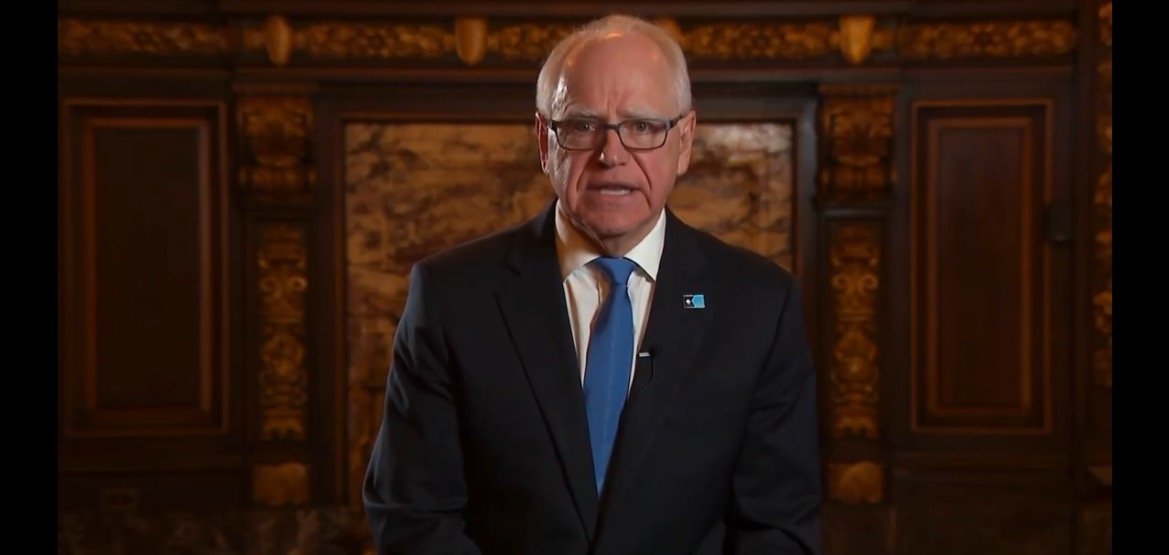 Man in a suit delivering a speech in an ornate room, emphasizing leadership and communication in a formal setting.