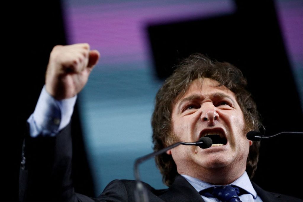 Man passionately delivering a speech with raised fist at a podium, conveying strong emotions and engaging the audience.