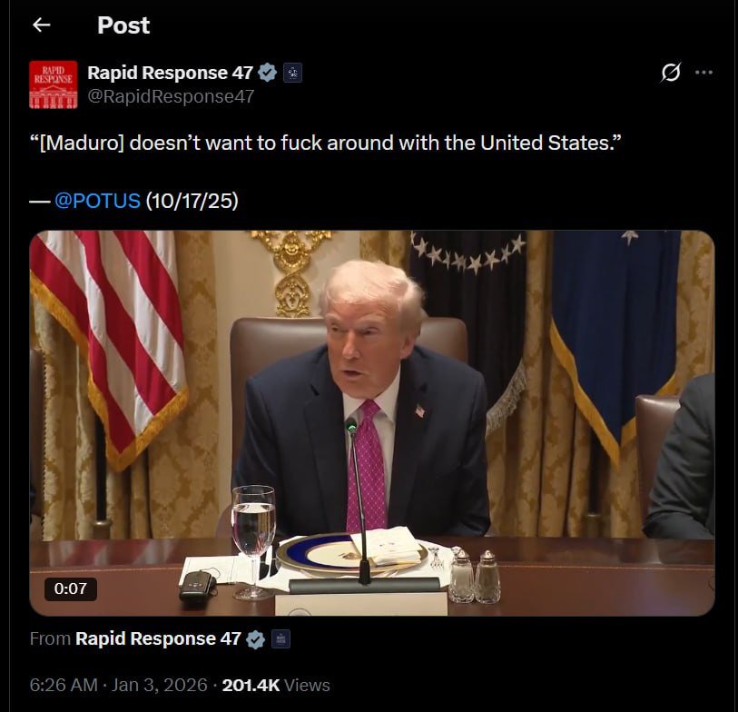 Donald Trump speaking during a meeting, addressing U.S. relations with Venezuela, with American flags in the background.
