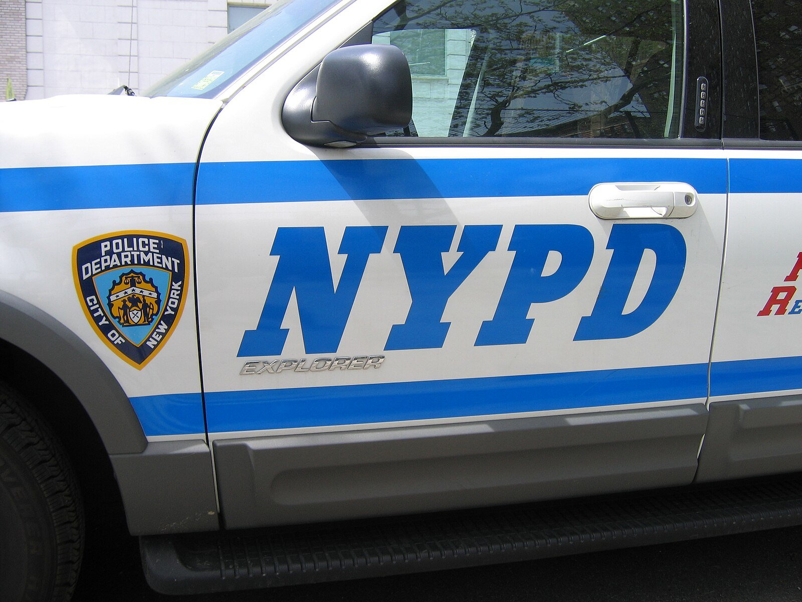 NYPD police vehicle featuring the department's emblem and blue stripes, showcasing law enforcement presence in New York City.