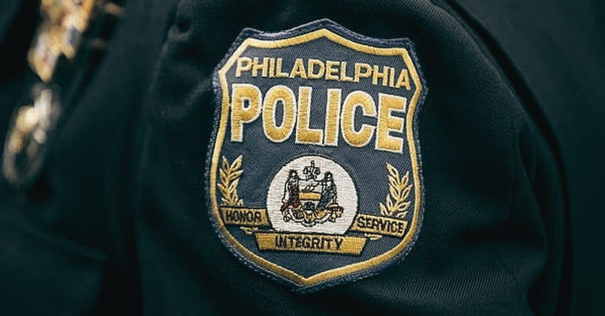 Close-up of the Philadelphia Police badge featuring the words "Honor, Service, Integrity" and an emblem representing law enforcement values.