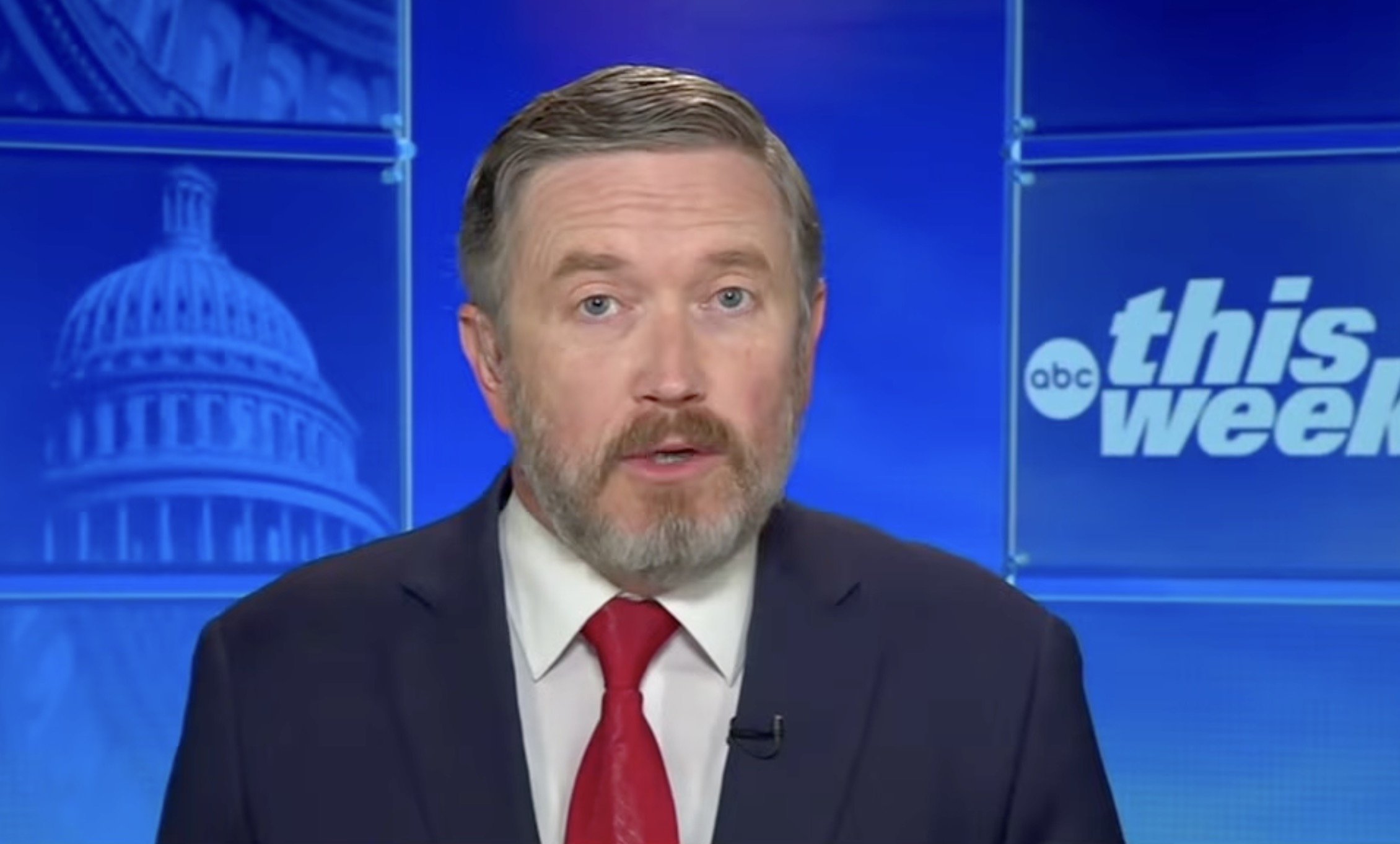 News anchor presenting on ABC's This Week, featuring a blue background with the U.S. Capitol in the backdrop.