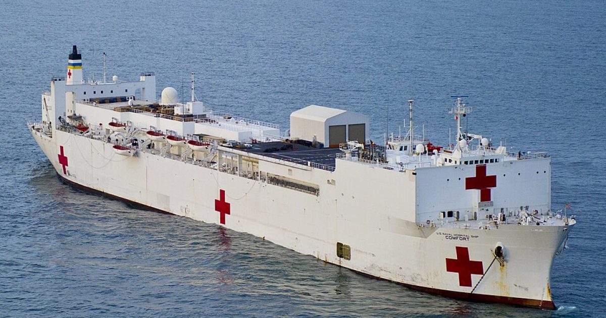 Hospital ship with red cross symbols sailing in open water, providing medical assistance and humanitarian aid.