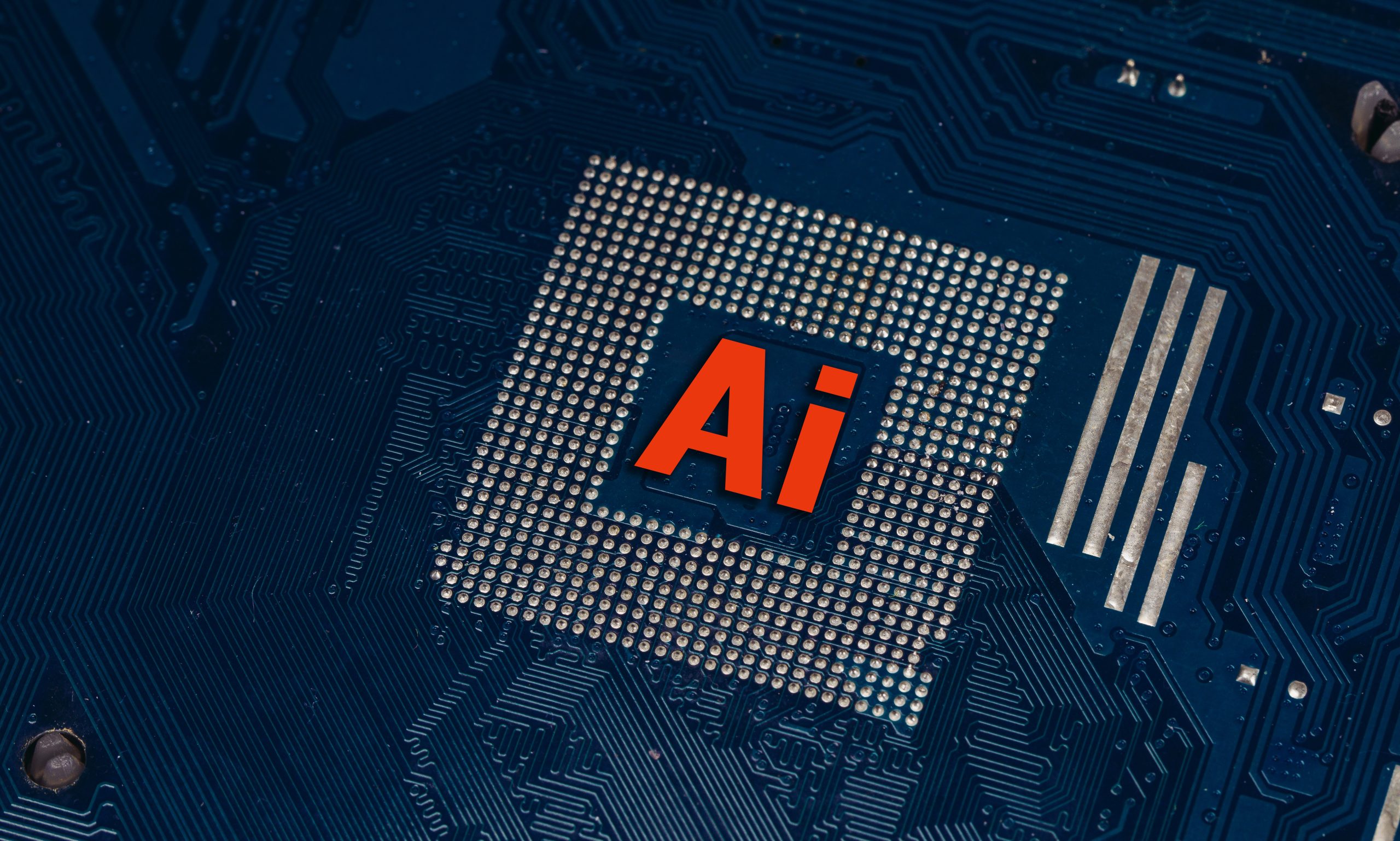 Close-up of a computer chip featuring the letters "Ai," symbolizing artificial intelligence technology on a blue circuit board background.