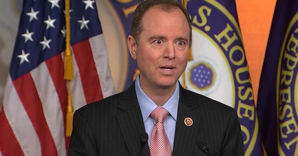 U.S. Congressman Adam Schiff speaking at a press conference with American flags in the background, addressing key political issues.
