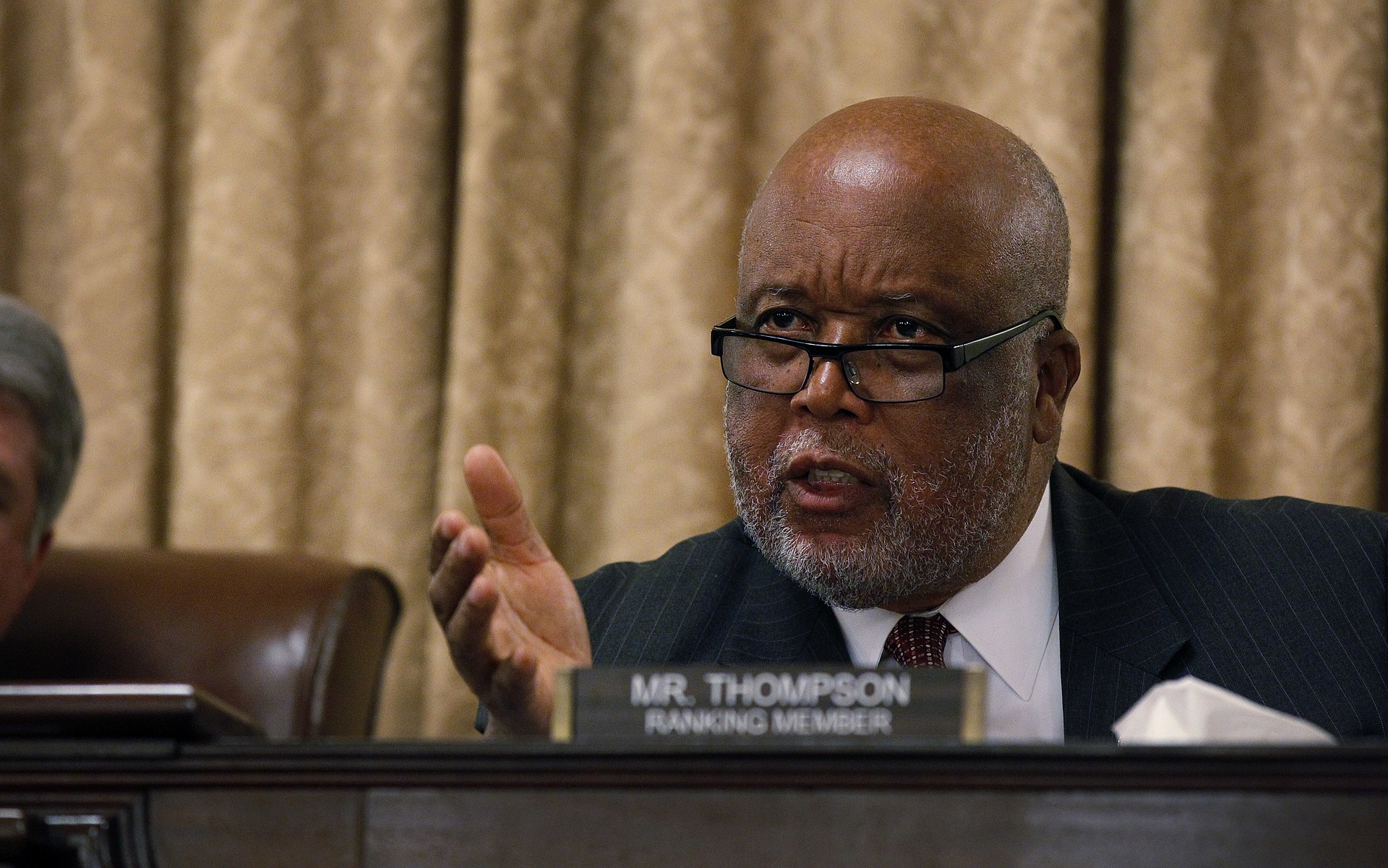 A congressional member passionately speaking during a committee meeting with a focus on governance and policy discussions.