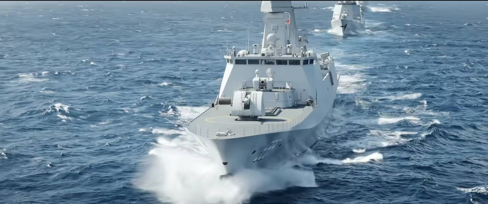 A modern naval warship navigates through choppy sea waters, showcasing advanced military technology and design.
