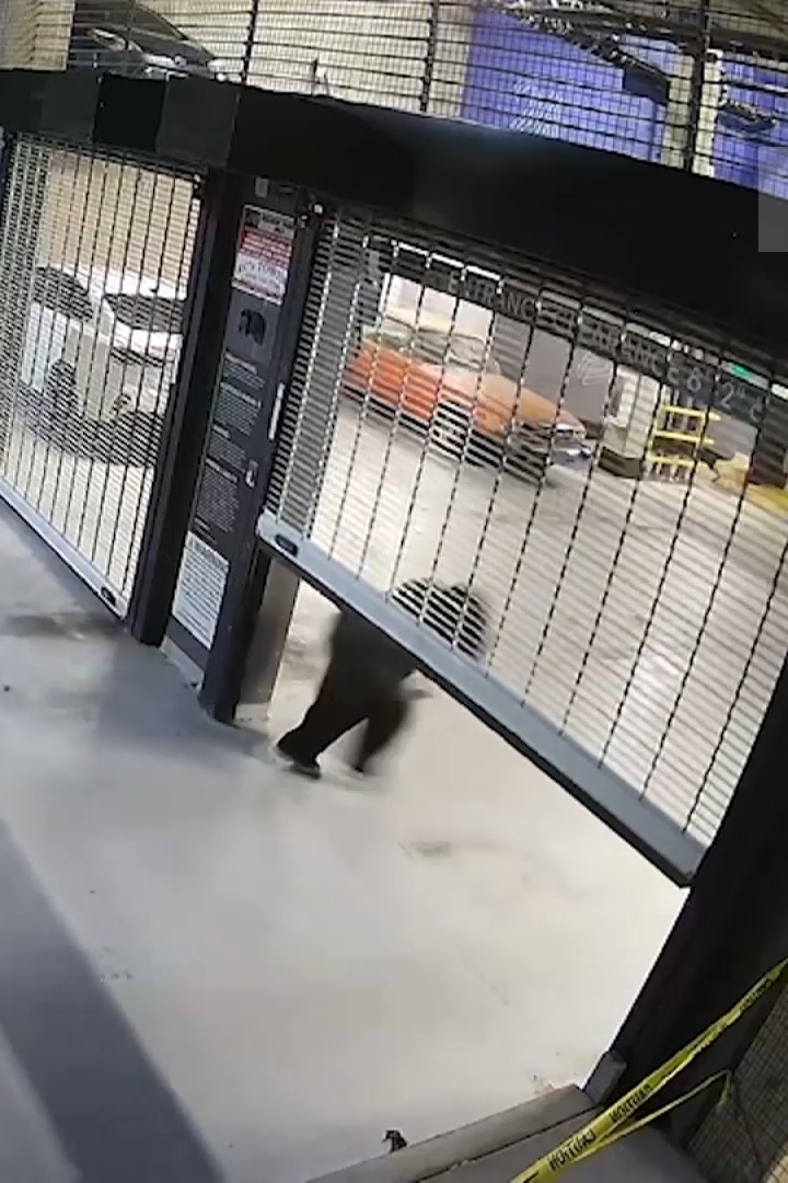Surveillance camera footage of Huda Mustafa walking through an apartment complex while talking on her phone