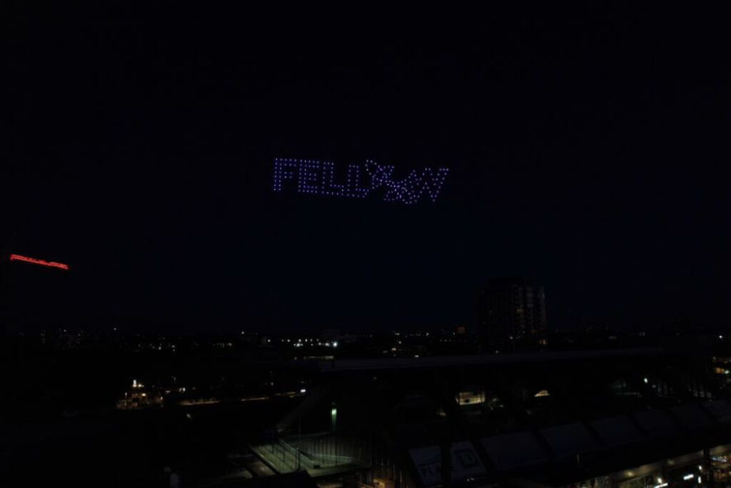 Drones produce the Fellow logo in the night sky