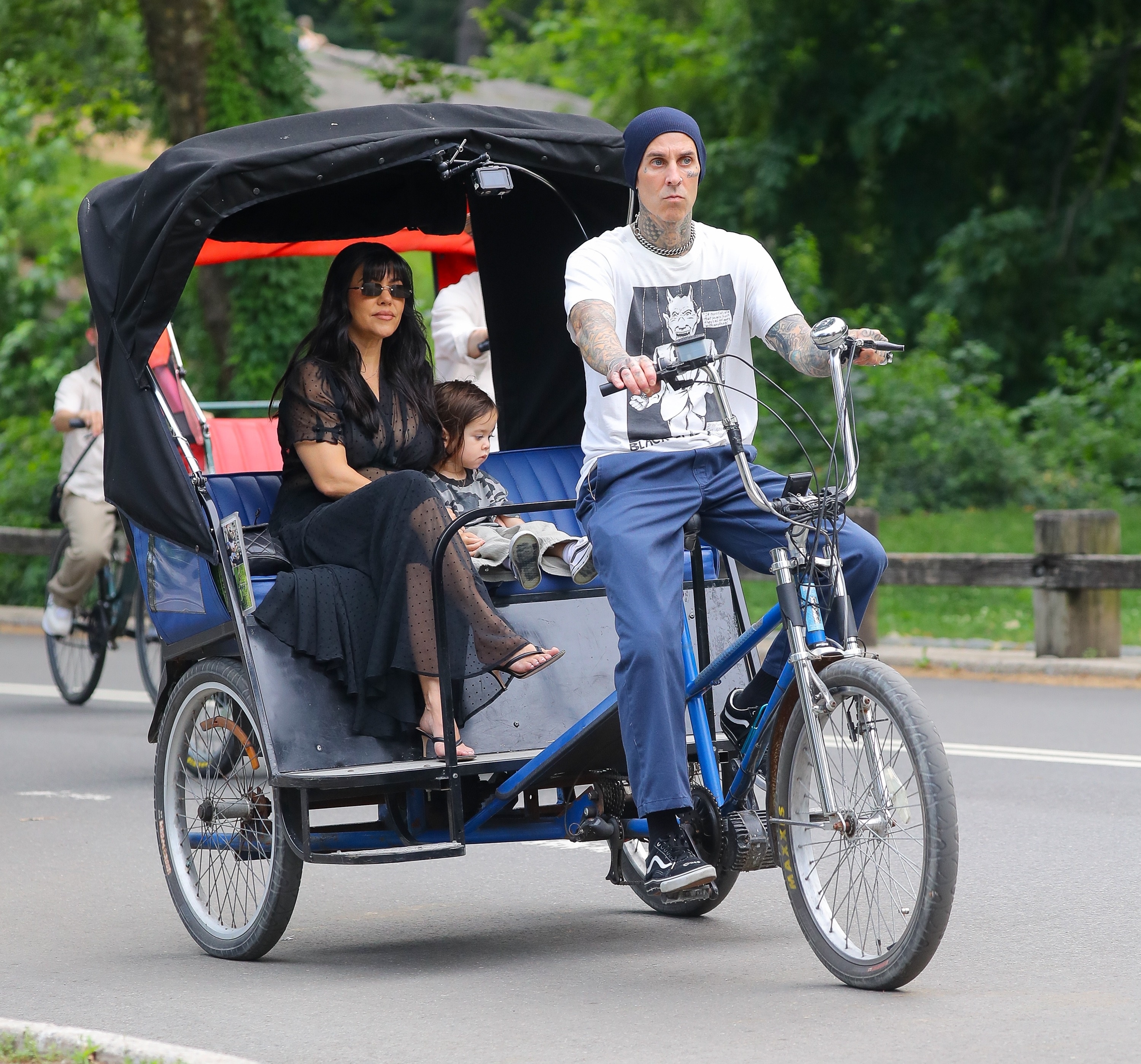 Travis Barker pedaling a pedicab with Kourtney Kardashian and their toddler son Rocky in Central Park