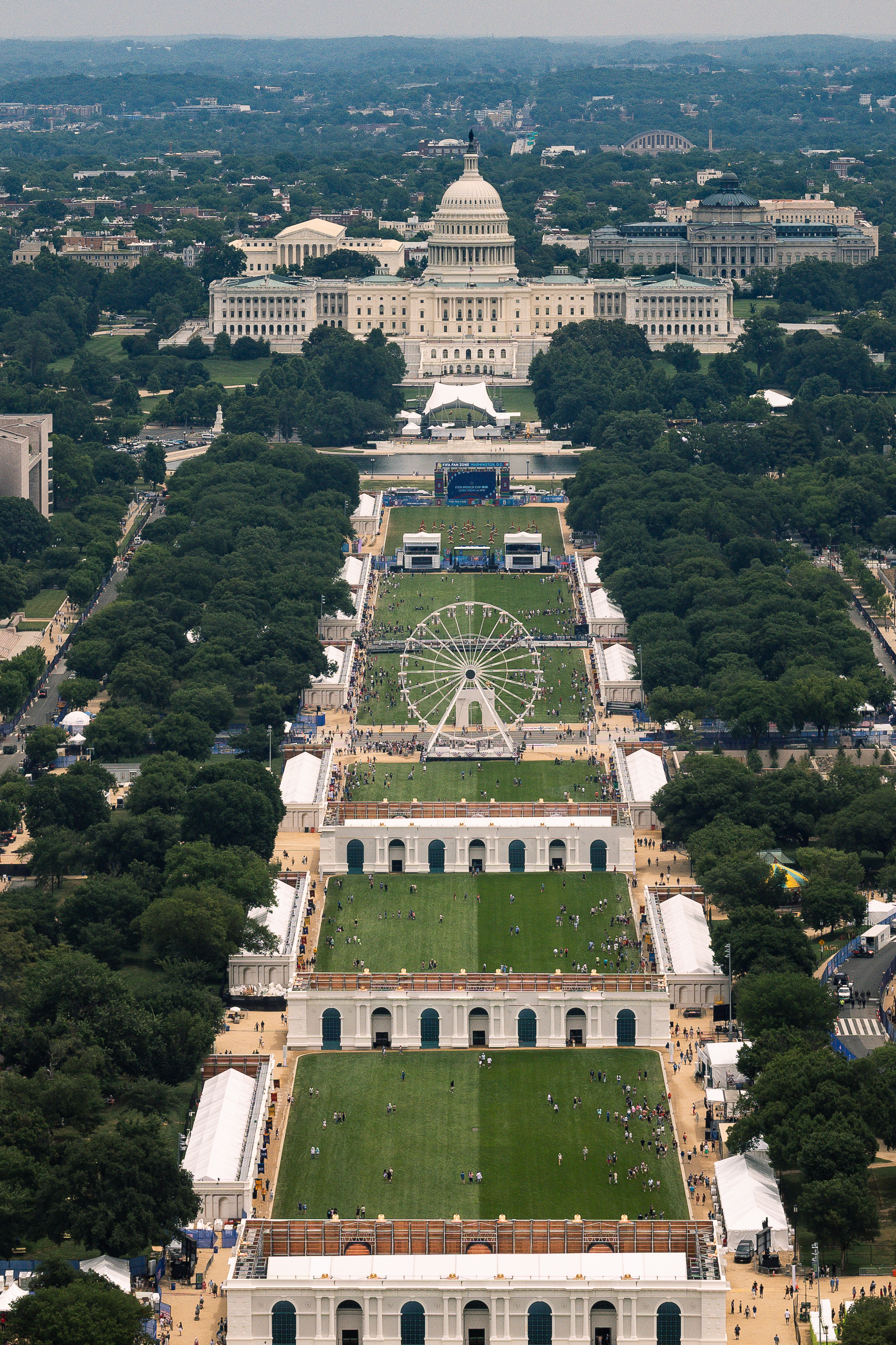 Aerial view of the National Mall showing the Freedom 250 Ferris wheel and state fair pavilions, with the U.S. Capitol in the background