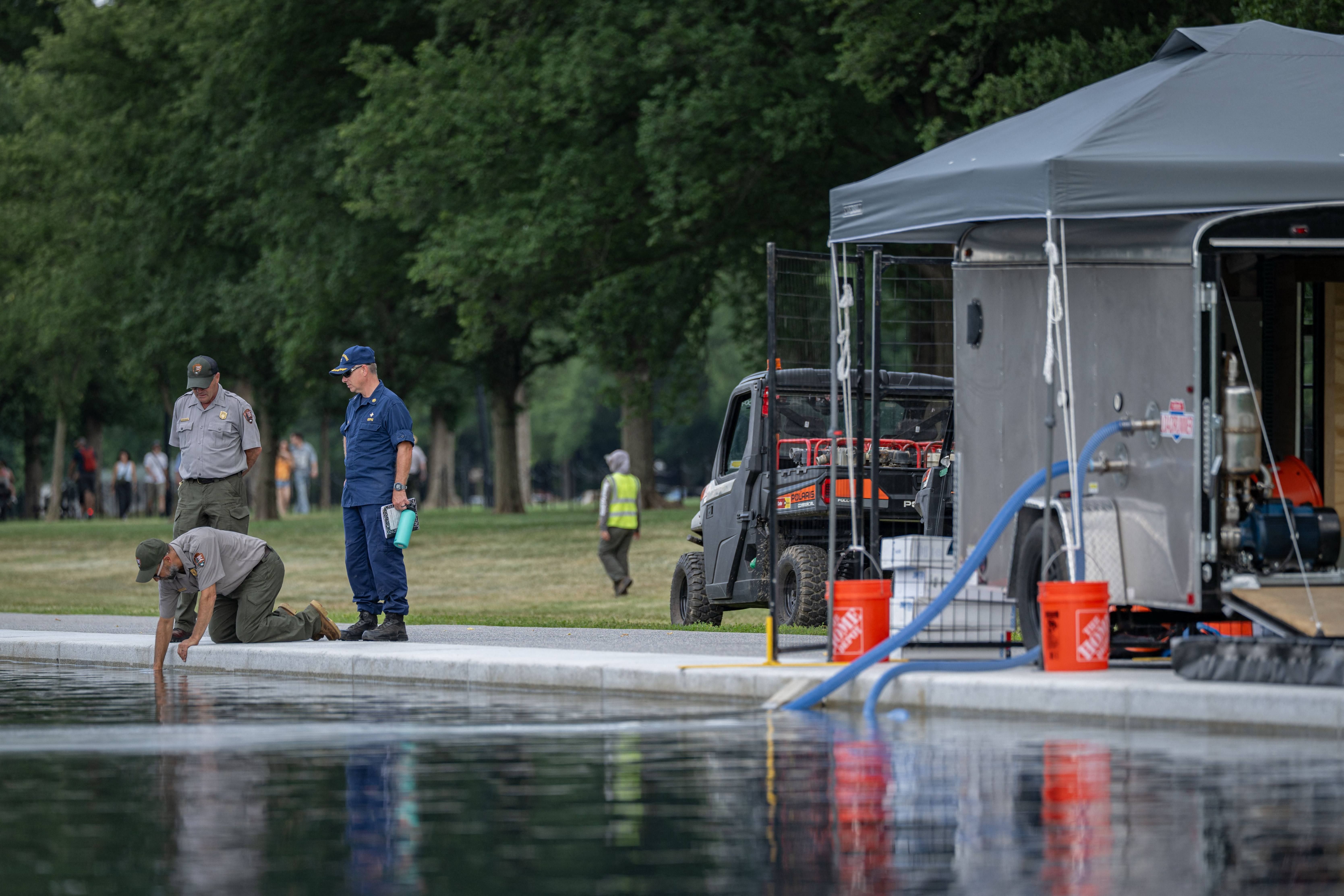 National Park Service crew members working to remove algae from the Lincoln Memorial Reflecting Pool on the National Mall in Washington, D.C.