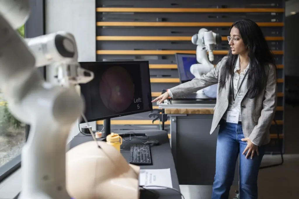 A woman operates a robotic arm.