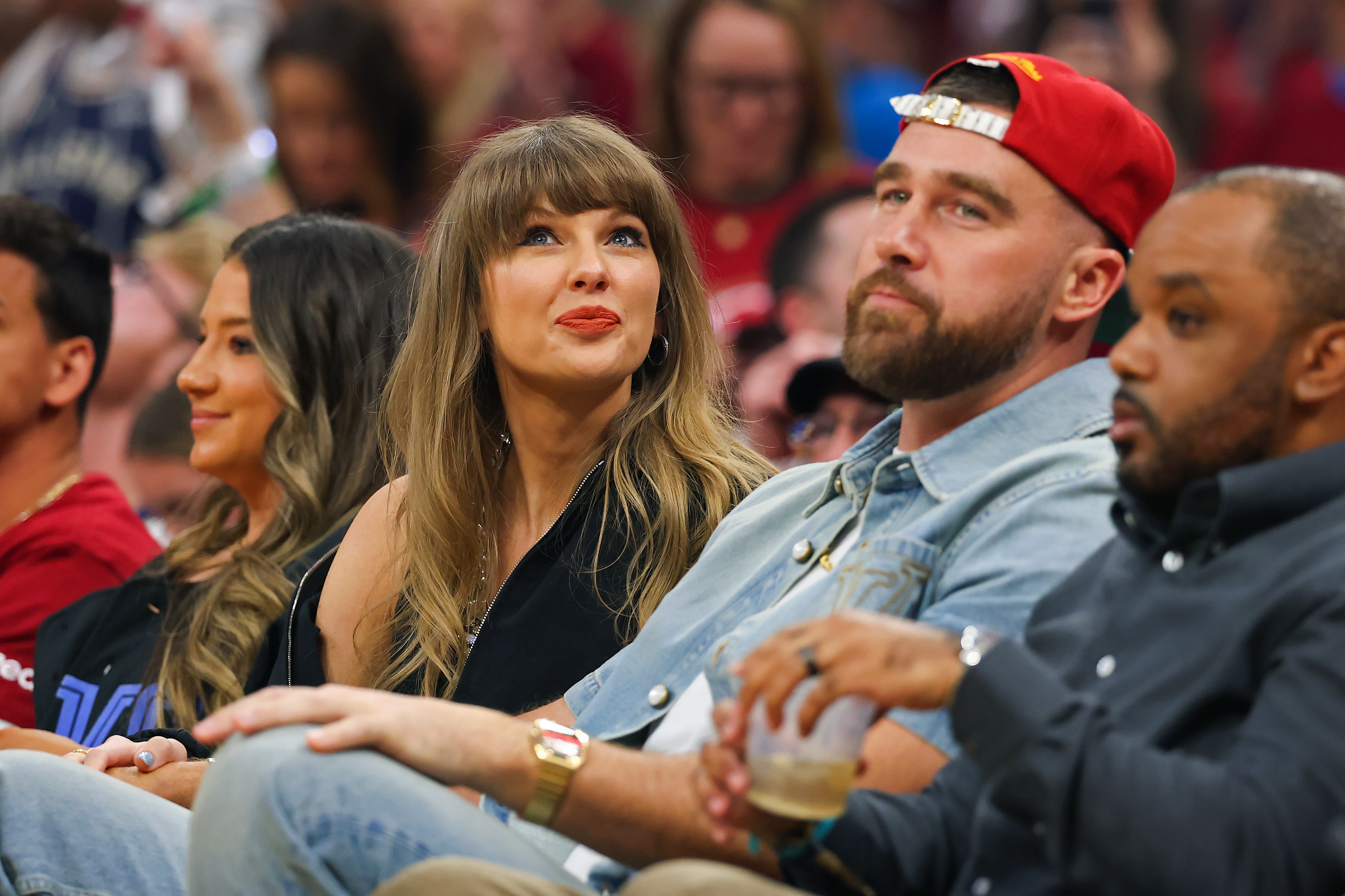 Taylor Swift and Travis Kelce sitting courtside at an NBA game at Rocket Arena in Cleveland