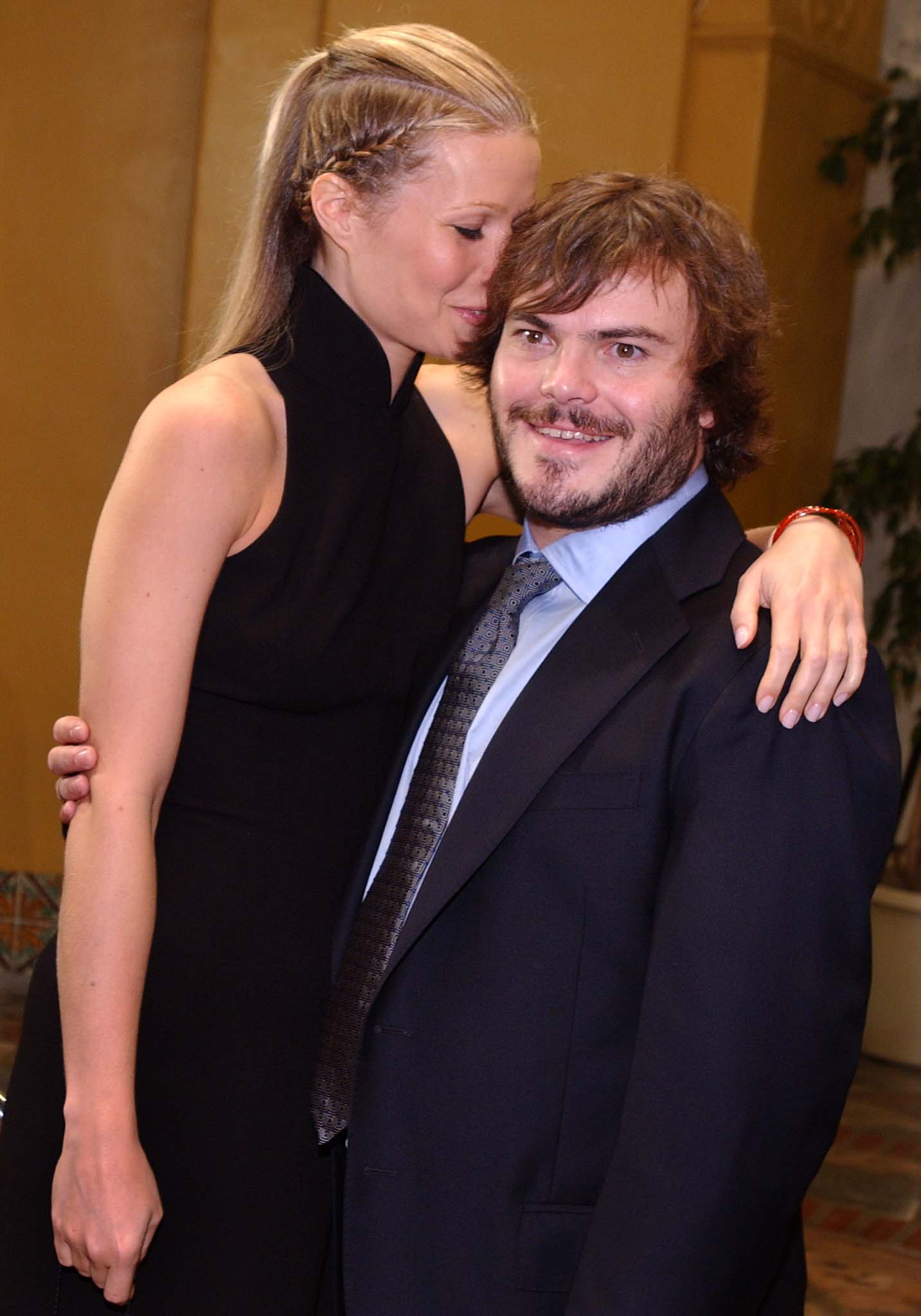 Gwyneth Paltrow in a black halter dress leans toward Jack Black in a suit and tie at a film premiere.