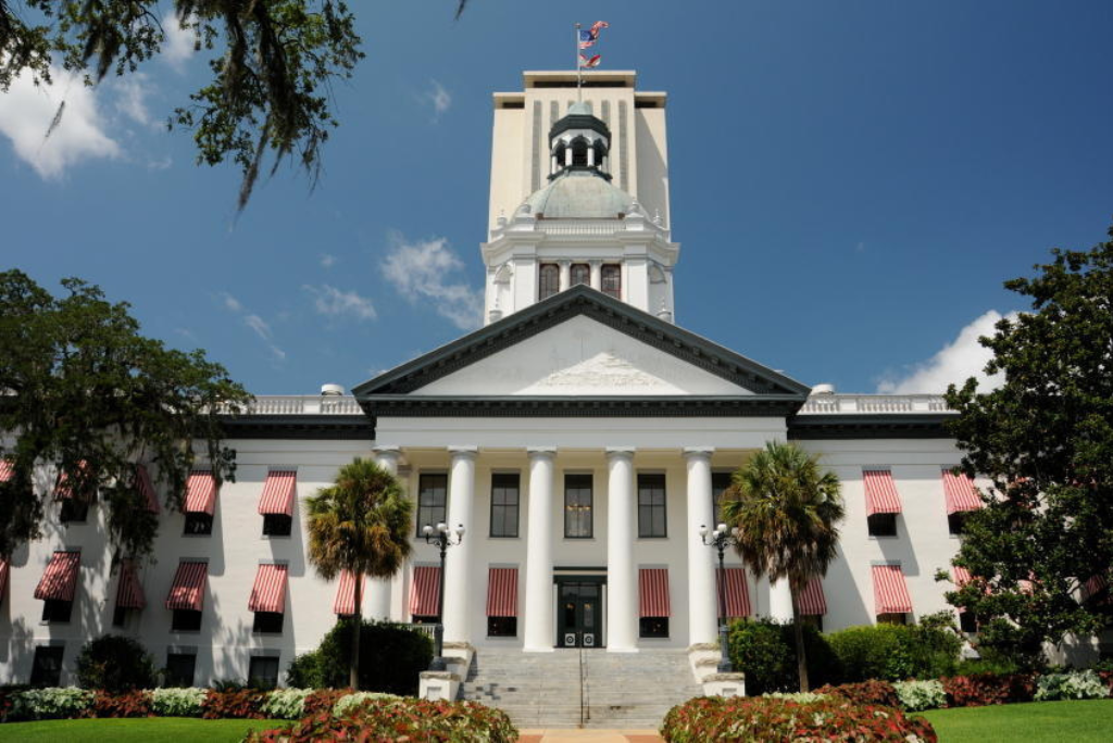 Florida State Capitol building with classic architecture, palm trees, and blue sky in Tallahassee, showcasing its historical significance and governmental function.