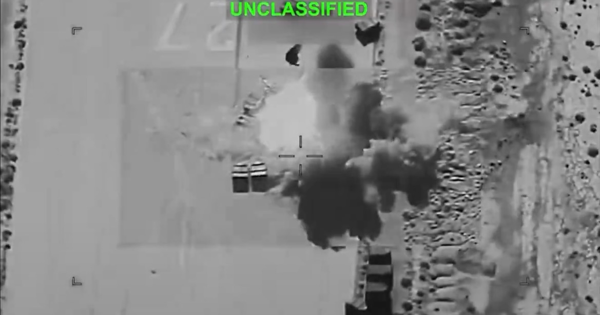 Aerial view of an explosion captured by military drone footage, showcasing smoke and debris in a conflict zone.