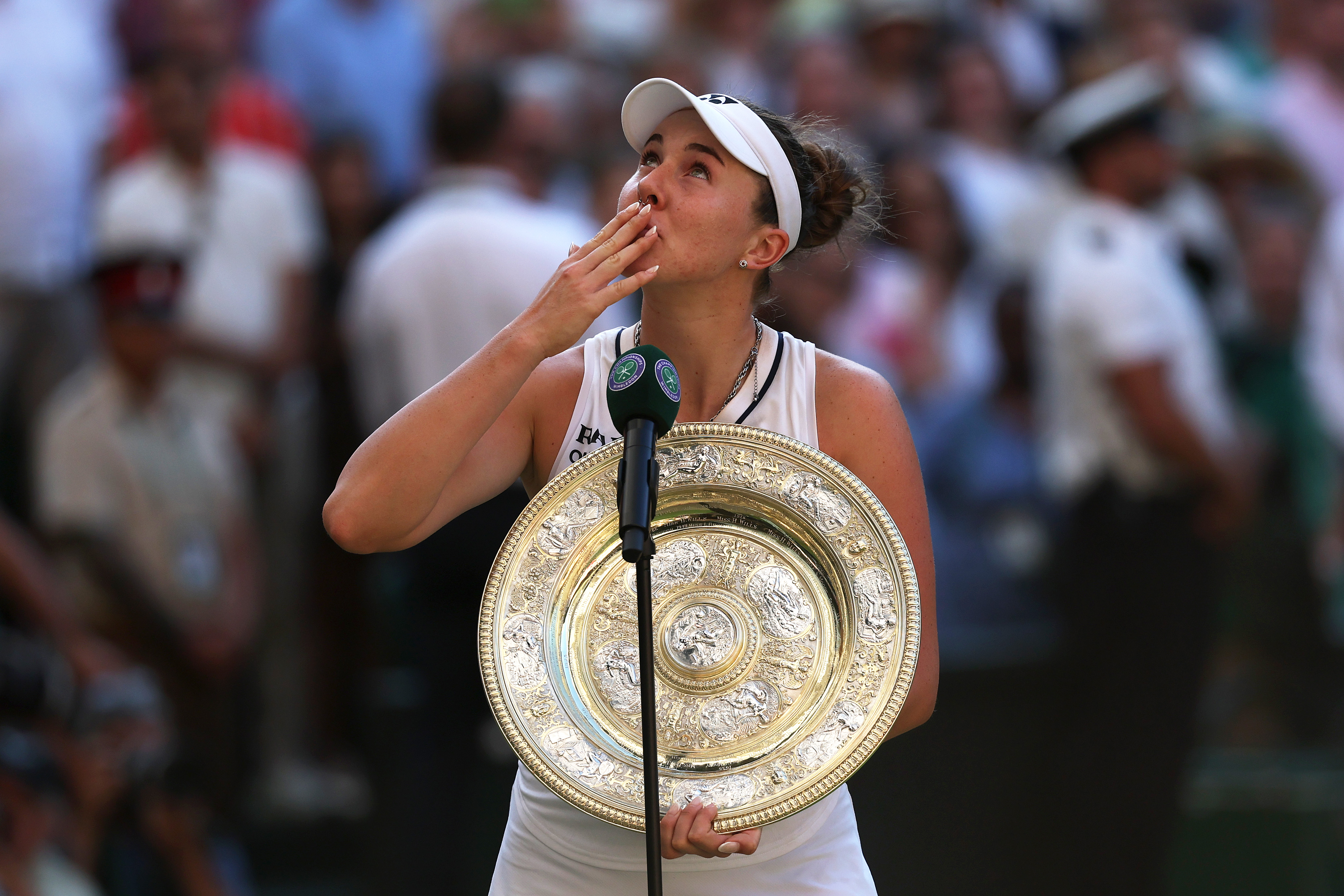 Linda Nosková holding the Venus Rosewater Dish and blowing a kiss during her on-court interview after winning the Wimbledon 2026 Ladies' Singles final