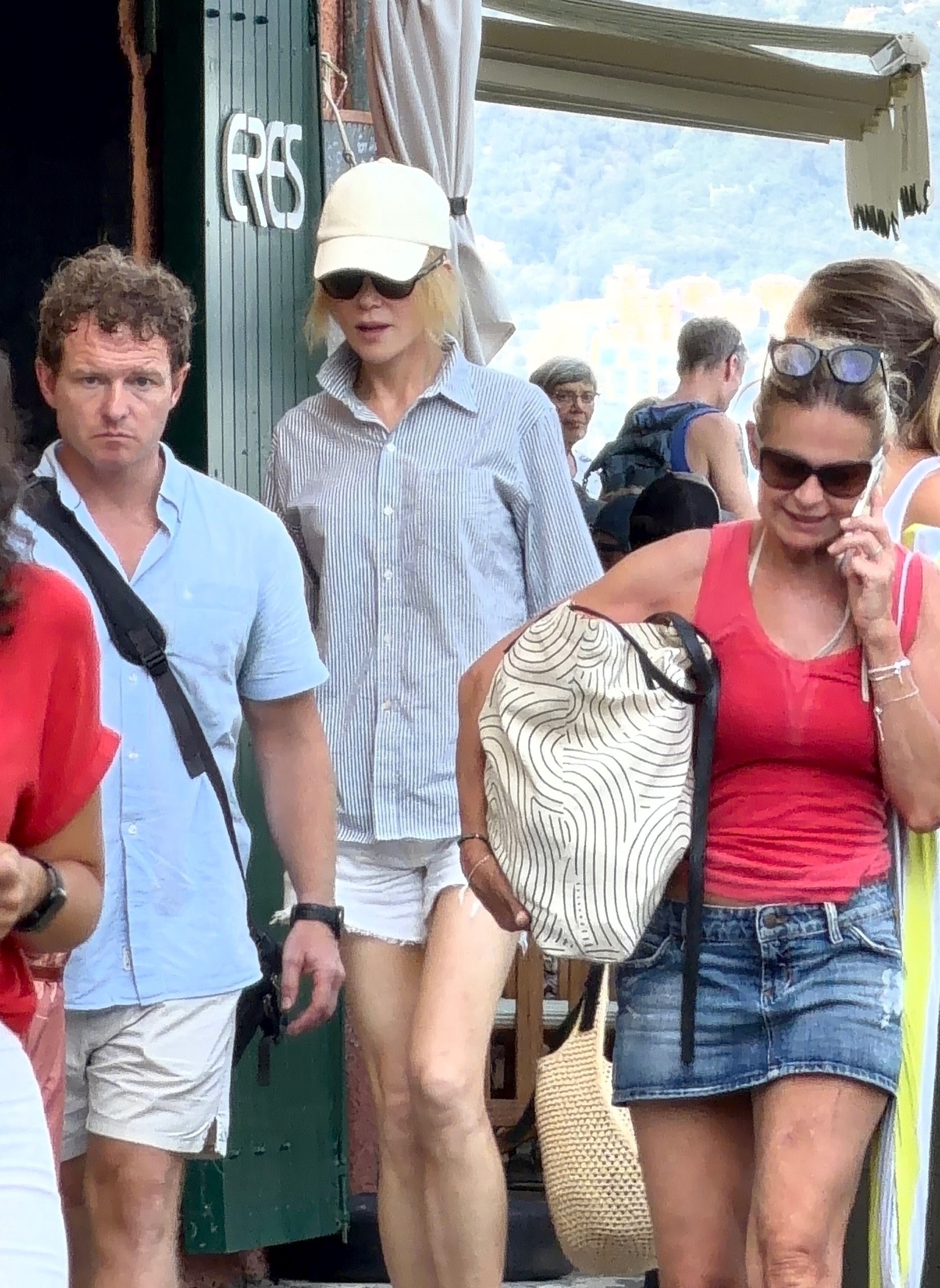 Nicole Kidman in a striped shirt, denim shorts, and trainers boarding a boat in Portofino with her family