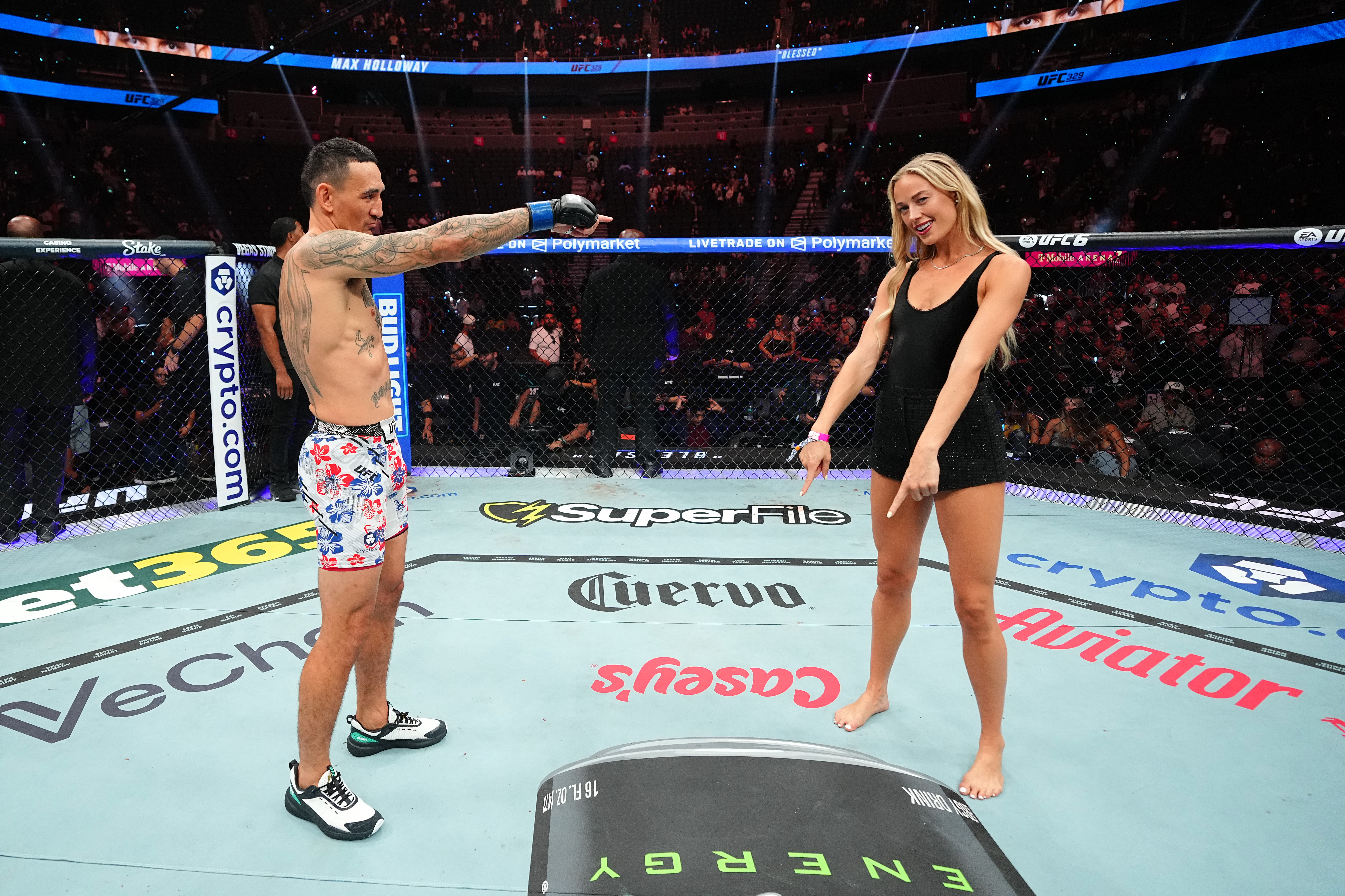 UFC fighter Max Holloway in floral shorts pointing at Sophie Cunningham, who smiles back, standing inside the UFC Octagon at T-Mobile Arena.