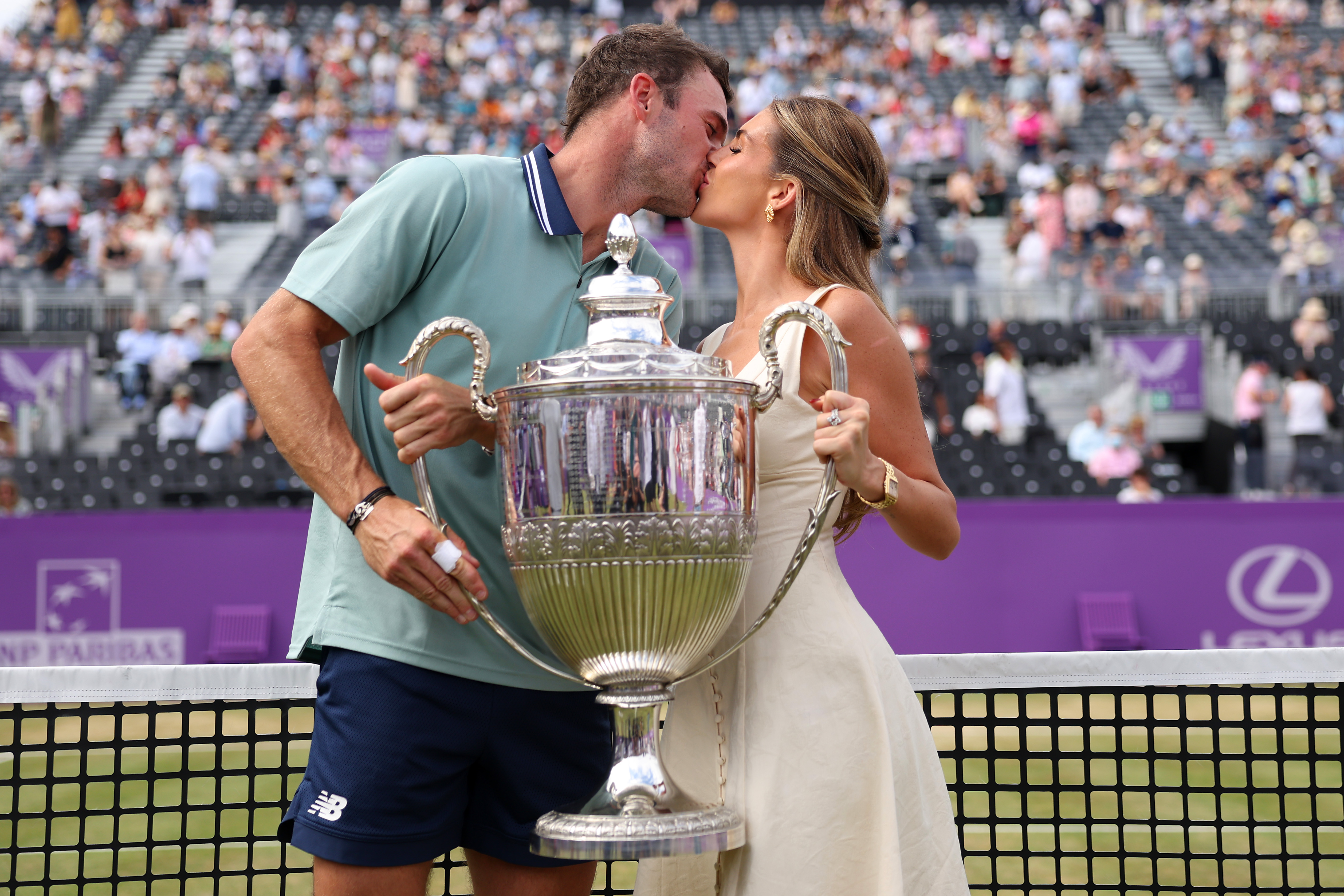 Tommy Paul and Paige Lorenze posing together with the cinch Championships 2024 winners trophy at The Queen's Club in London