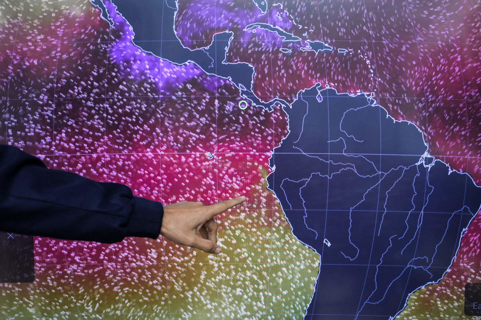 A meteorologist points to a NOAA sea surface temperature map showing warm waters off the Peruvian coast in Panama City