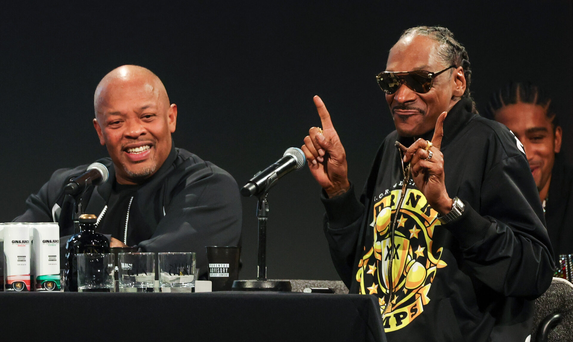 Dr. Dre and Snoop Dogg seated together during a live episode of the Drink Champs podcast at ComplexCon 2024 in Las Vegas