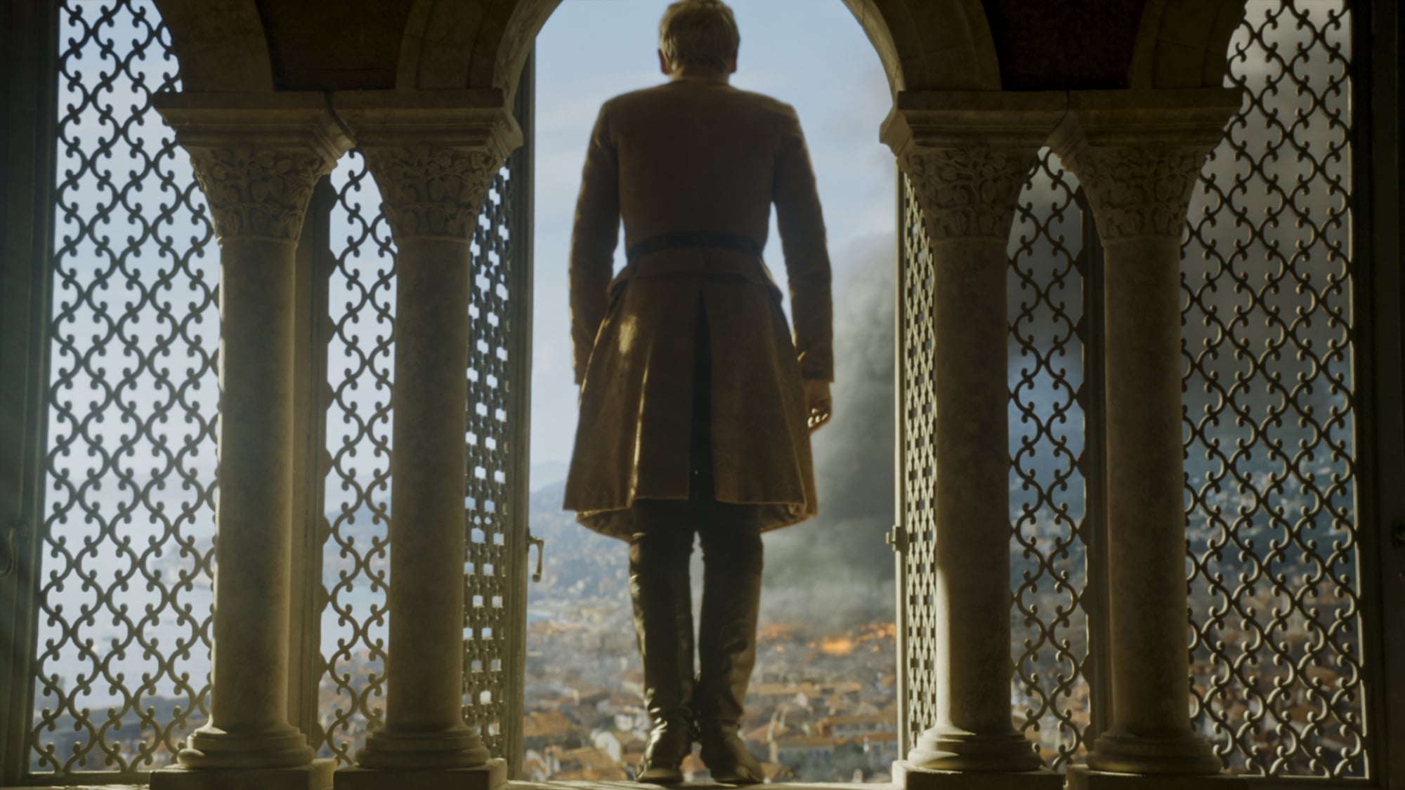 A man stands on the edge of a window overlooking a city, as if about to jump.
