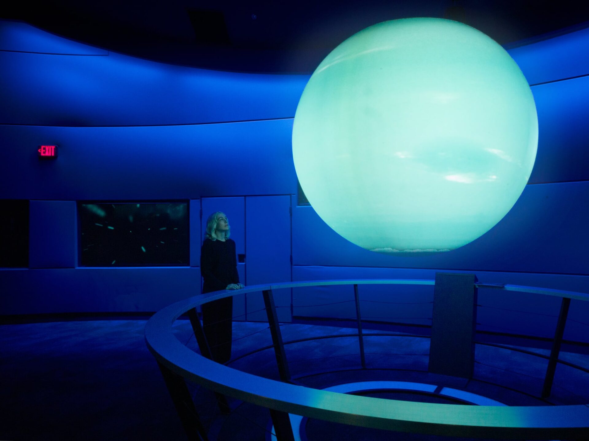 Phoebe Bridgers at the Liberty Science Center in Jersey City looking up at an illuminatedplanet