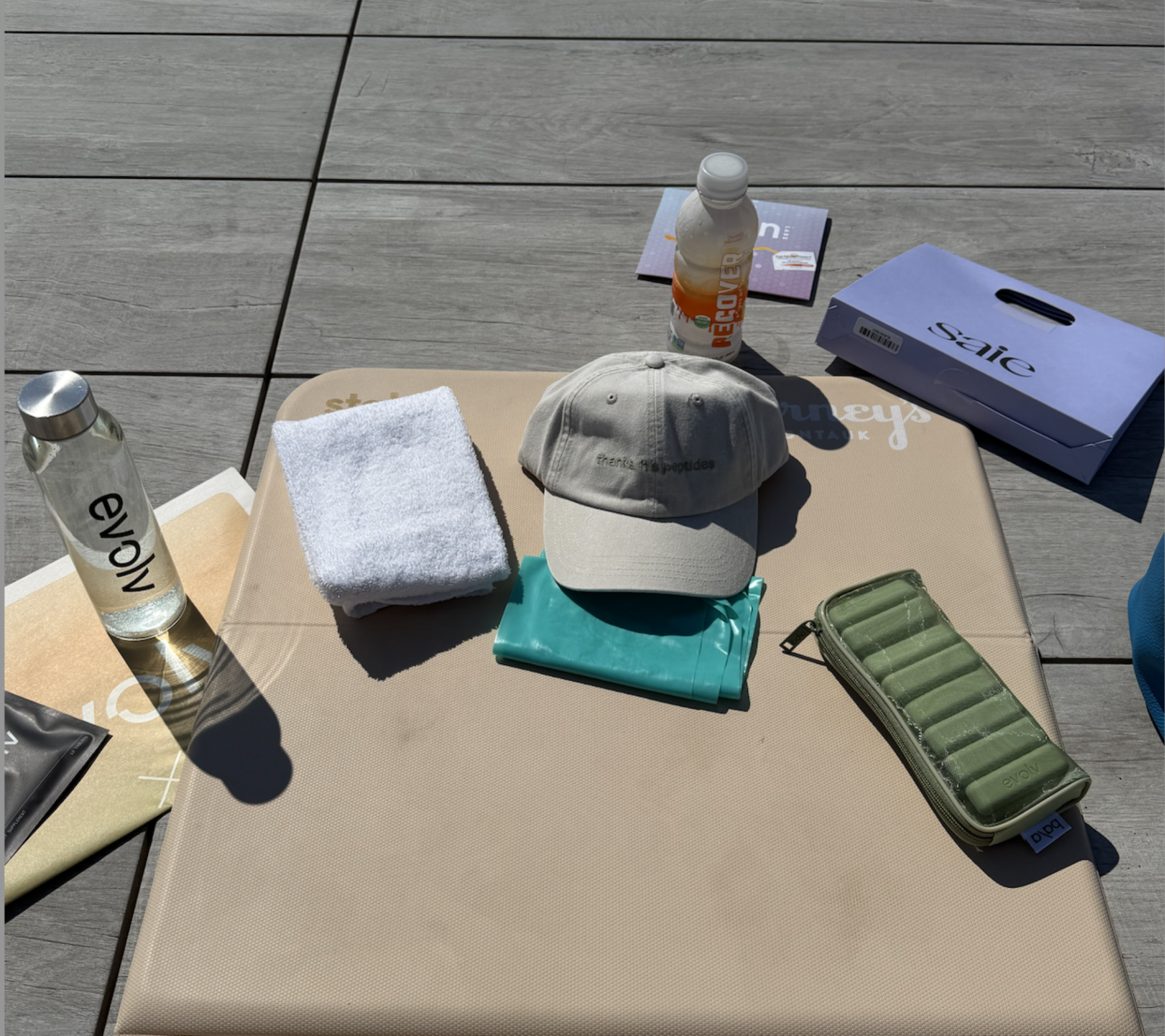 A variety of wellness gifted items and a hat laid out over a yoga mat
