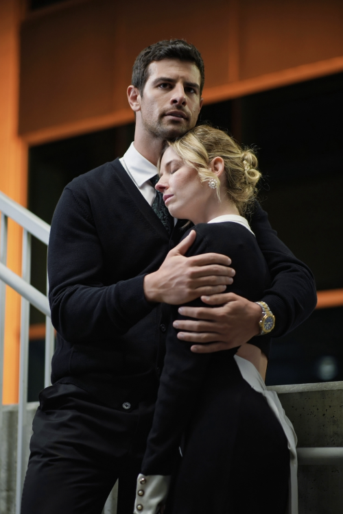 A man and a woman embrace on a staircase