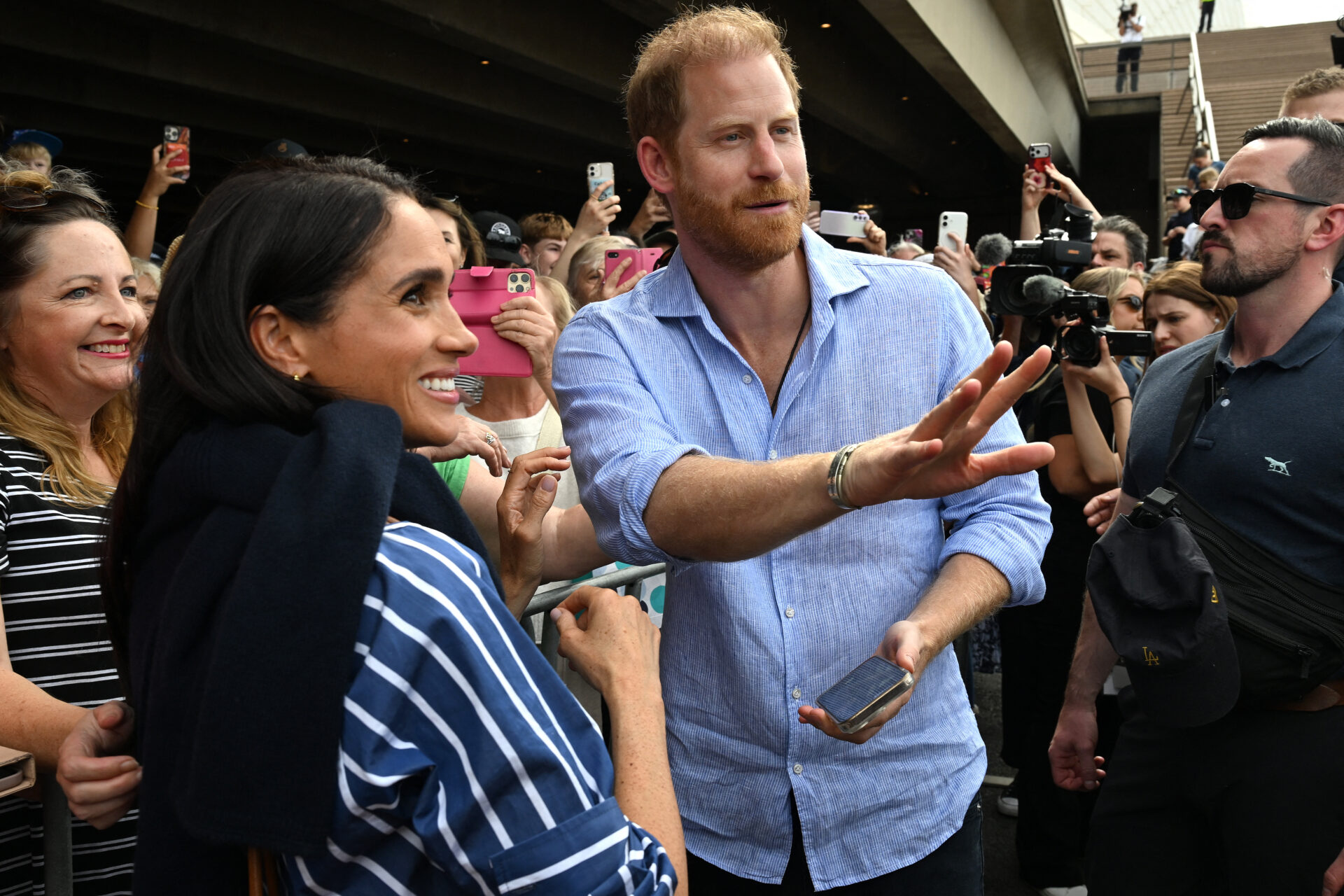 Prince Harry and Meghan Markle greeting members of the public outside the Sydney Opera House