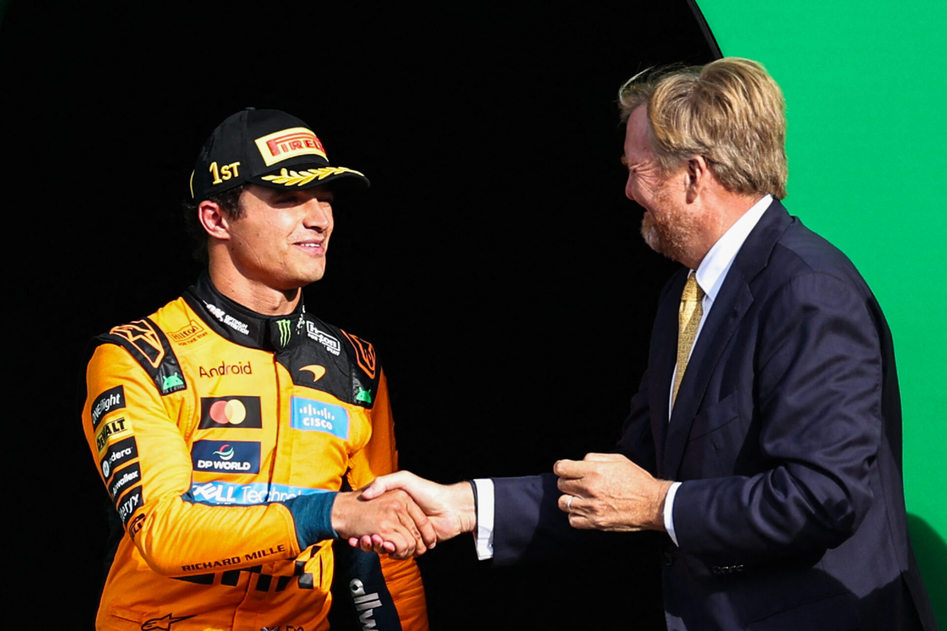 Lando Norris shaking hands with King Willem-Alexander on the podium at the Dutch Grand Prix at Circuit Zandvoort