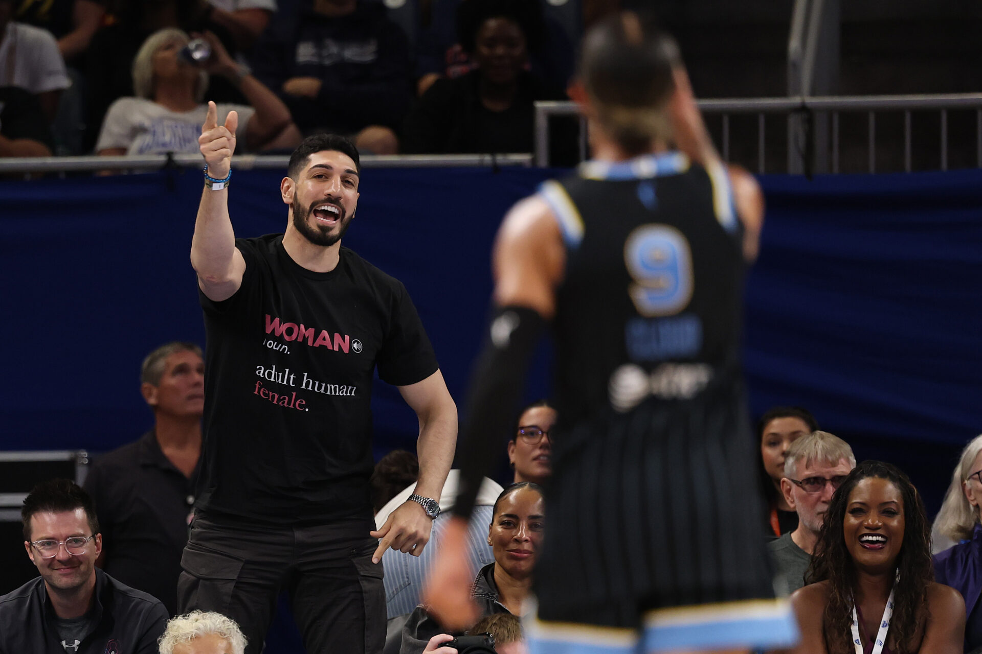 Enes Kanter Freedom pointing and yelling at Chicago Sky player number 9 Natasha Cloud courtside during a WNBA game.