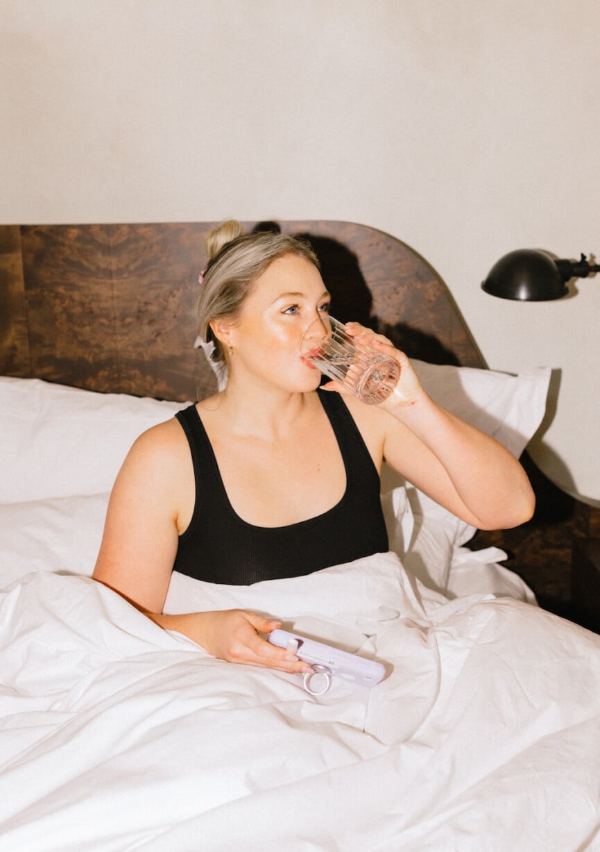 woman drinking water in bed