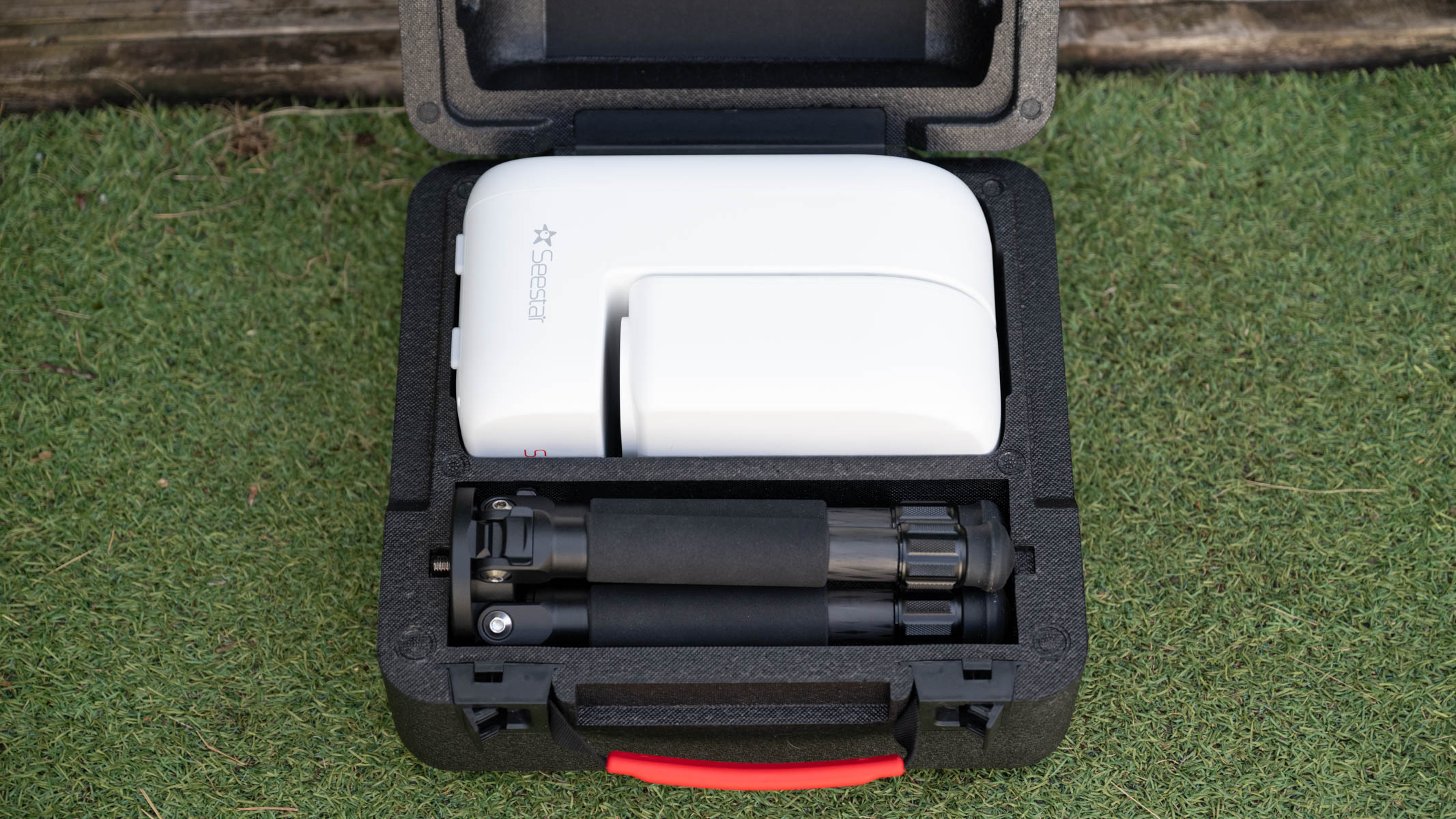 ZWO Seestar S50 Pro on a tripod against a green shed