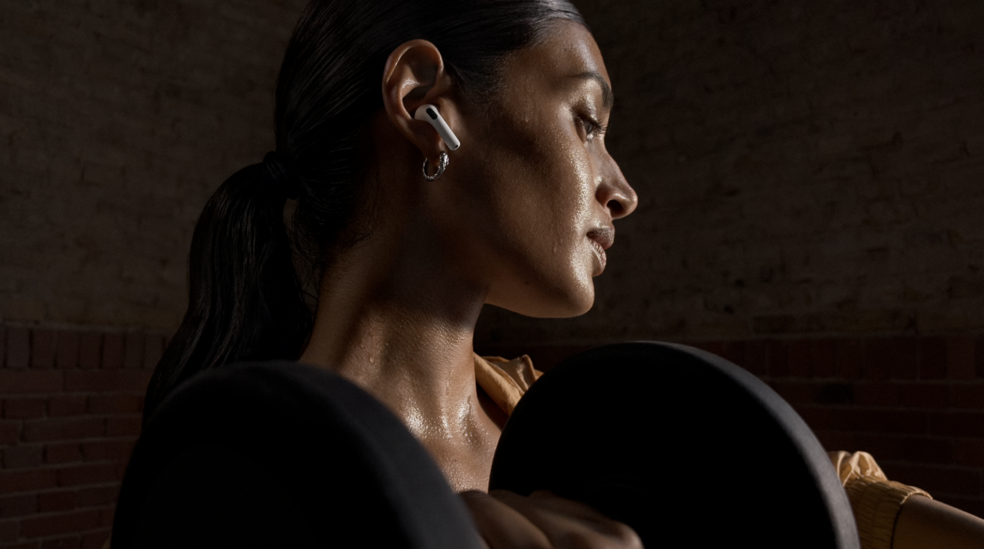 woman wearing new airpods 5 earbuds in gym