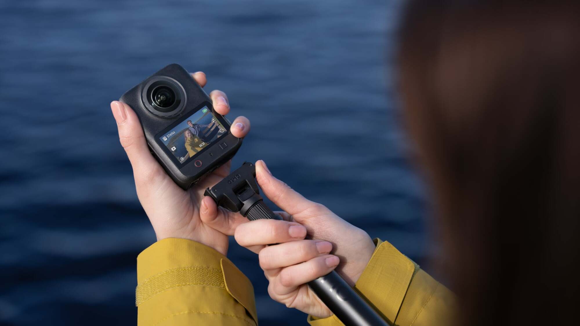 The DJI Osmo 360 III being attached to a selfie stick.
