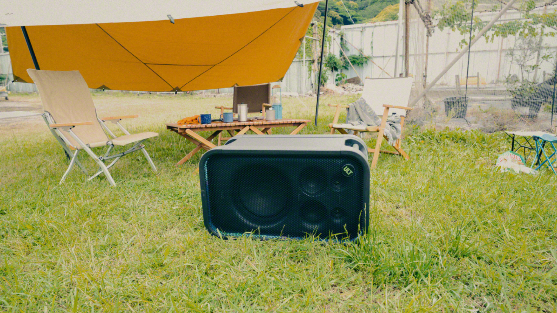 Sony ULT Tower 7 on its side in the grass near a camping setup
